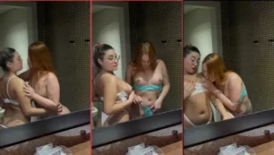 Contenido para adultos con temática lésbica, donde amigas intercambian besos y caricias en un ambiente de baño